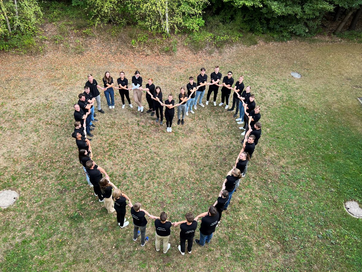2022 beginnen 19 Azubis und Dual Studierende ihre Ausbildung bei Pepperl+Fuchs. Gruppenfoto in Form eines Herzens.