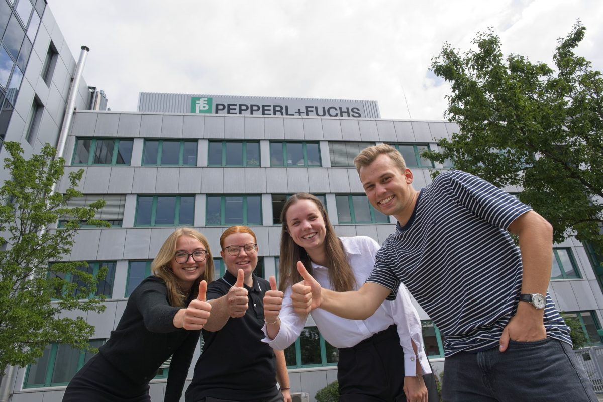 Hier sind vier unserer Auszubildenden bzw. dual Studierenden vor dem Pepperl+Fuchs Gebäude in Mannheim zu sehen. Sie strecken ihre Daumen in die Höhe und lachen in die Kamera.