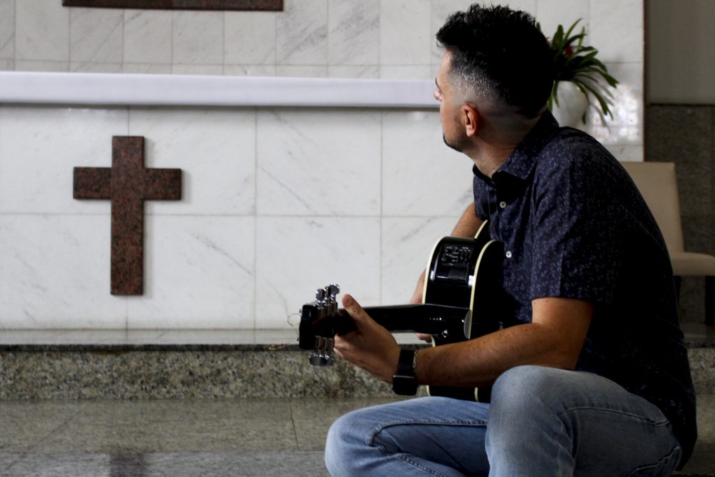 Dênis mit Gitarre in einer Kirche