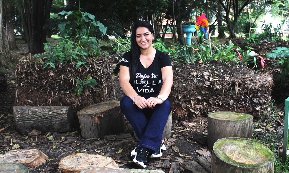 CEIBA MUNAY: In ihrer Freizeit setzt sich Marcella mit ihrer Stiftung für die beiden Hauptaspekte Bildung und Natur ein. Marcela sitzt draußen im Grünen. 