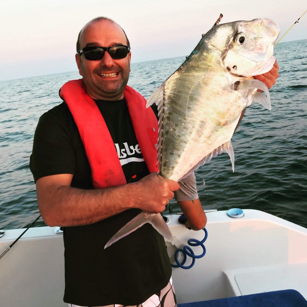 Am liebsten geht Stefano in seiner Freizeit angeln. Hier auf dem Bild sieht man ihn auf einem Boot stehen mit einem großen geangelten Fisch in der Hand.