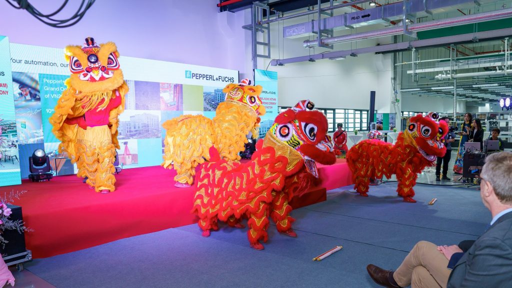 Bei der Eröffnungsfeier des Neubaus von Pepperl+Fuchs in Vietnam tanzen beim traditionellen "Lion Dance" als asiatische Löwen verkleidete Menschen vor den eingeladenen Gästen.